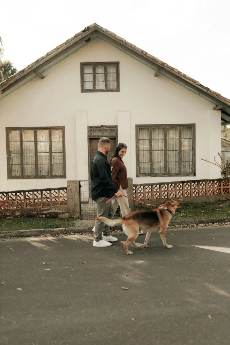Couple walking a German Shepherd outdoors